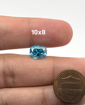 Sea blue elongated cushion cut moissanite gemstone measuring 10x8mm with exceptional brilliance and sparkle.