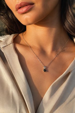 Woman wearing platinum black diamond pendant with white gold chain styled for evening round rose cut diamond pendant 