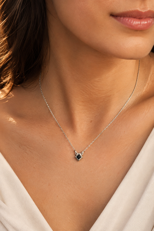Black diamond pendant worn with an elegant outfit showing a princess cut black diamond pendant style 