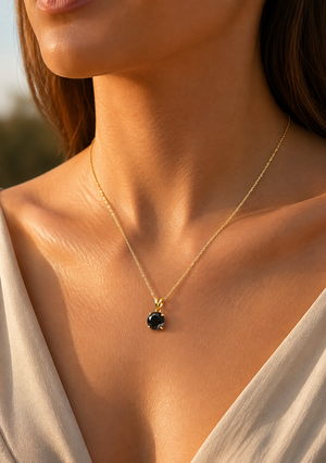 Woman wearing black diamond solitaire pendant 14k gold on her neckline for an elegant evening look
