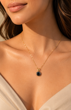 Black diamond pendant worn at the collarbone as a refined 14K yellow gold diamond necklace 