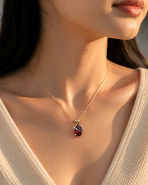 Woman wearing Garnet pendant necklace with a sophisticated evening outfit.
