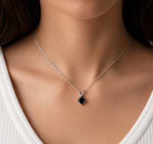 Black diamond solitaire pendant worn with a white gold chain for an elegant everyday necklace 