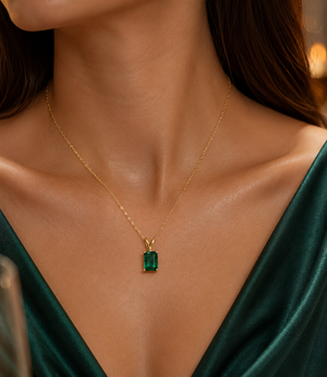 Woman wearing emerald pendant for anniversary dinner featuring emerald solitaire pendant styling 