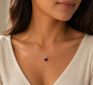 Elegant woman wearing a heart Garnet pendant with evening attire.