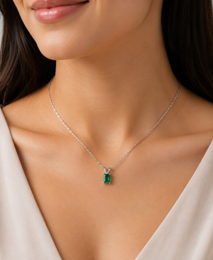 Woman wearing a natural emerald pendant with an 18K white gold emerald necklace for elegant styling 