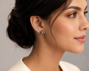 Woman wearing Tahitian pearl earrings with elegant evening styling and white gold pearl stud earrings 