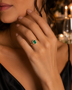 Woman wearing emerald diamond ring at elegant anniversary dinner romantic jewelry gift