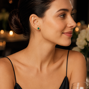 Woman wearing emerald stud earrings styled for anniversary dinner elegant gemstone earrings gift
