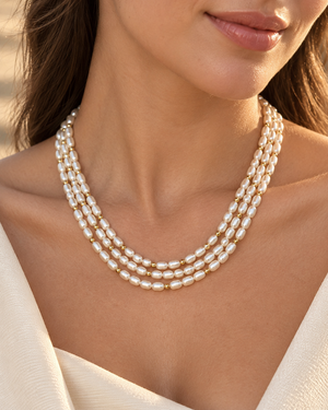 Three layered pearl strands worn at the neckline showing the elegant proportions of an 18 inch pearl necklace 