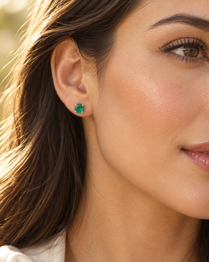 Emerald studs worn on the ear for an evening look, featuring elegant platinum emerald earrings 