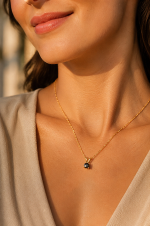 Black diamond pendant worn at the neckline featuring a rose cut black diamond necklace in yellow gold 