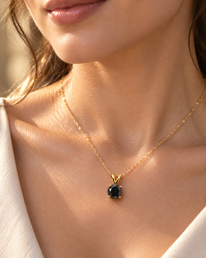 Black diamond pendant worn at the neckline as a 14K yellow gold black diamond necklace 