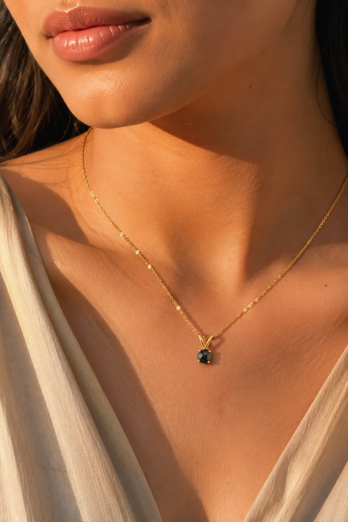 Black diamond pendant worn at neckline with 14K gold chain as an elegant necklace for women 