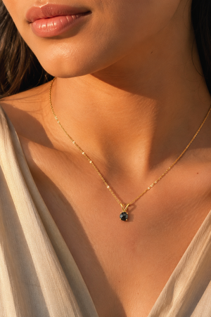 Black diamond pendant worn at neckline with 14K gold chain as an elegant necklace for women 