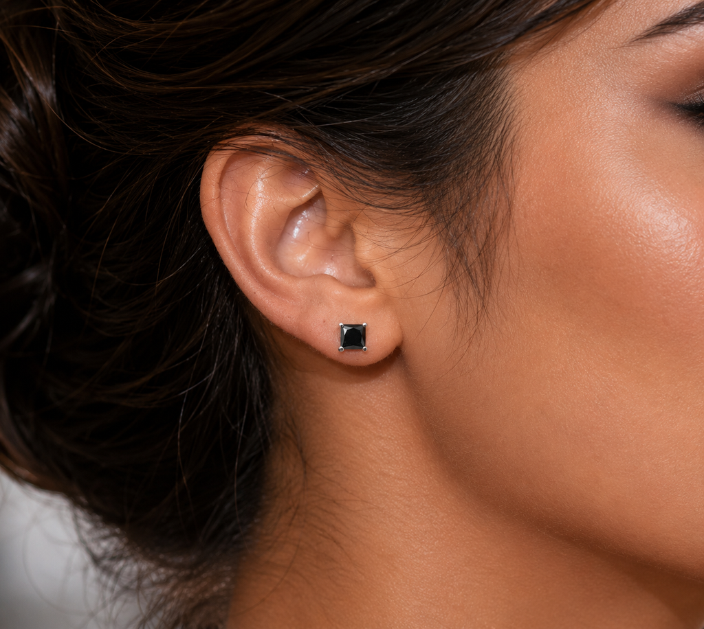Earrings worn on ears at evening event featuring princess cut black diamond earrings 