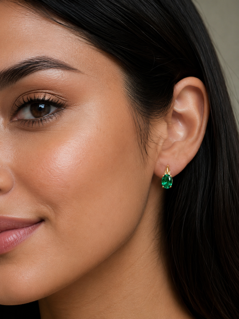 Emerald earrings worn on ears during celebration featuring oval emerald earrings styling 