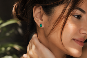 Woman wearing emerald stud earrings during dinner styling oval emerald gold earrings 
