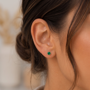 Woman wearing petite emerald stud earrings styled for elegant everyday office jewelry inspiration