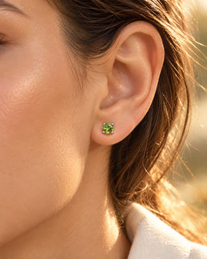 Natural Peridot Scroll Stud Earrings worn on an ear; 4mm peridot earrings in white gold for daytime styling 