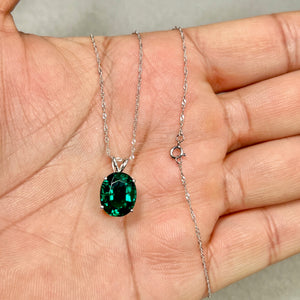 Women’s oval emerald solitaire pendant in 14K white gold with 4.01–4.91 carat lab created emerald and four-prong setting.
Modern Heirloom emerald pendant showing medium-dark green color, polished white gold finish, and balanced everyday scale.