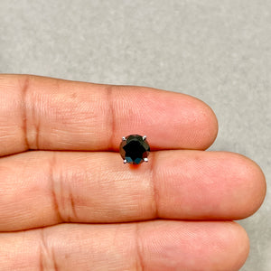 Close-up of a men’s platinum stud earring showing a round brilliant black diamond with prong setting, deep black tone, compact 7.3 mm scale, and screwback post. 