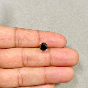 Close-up of a platinum men’s stud earring with a round brilliant black diamond, deep matte-black tone, sculptural prong setting, and compact 7.3 mm scale 