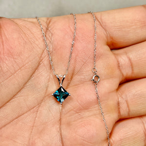 6 mm princess-cut London Blue Topaz set in polished 14K white gold, showing deep blue color and sculptural prong setting. 