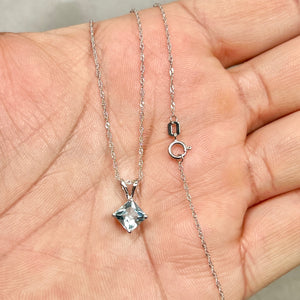 Princess-cut light blue aquamarine solitaire pendant set in platinum, featuring a sharp 6 mm gemstone suspended from an 18-inch white gold Singapore chain with fine prong detailing. 