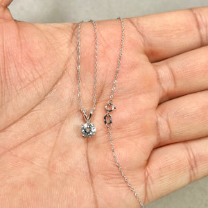 Round 6 mm light blue aquamarine solitaire pendant in polished 18K white gold with four-prong setting and slim Singapore chain. 