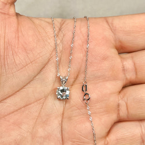 Light blue round aquamarine solitaire pendant in 14K white gold with sculptural scroll prong setting on an 18-inch Singapore chain 