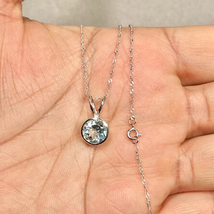 Round 8 mm light blue aquamarine solitaire in smooth bezel setting, crafted in polished 14K white gold with fine Singapore chain. 
