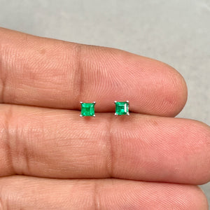 flat lay of emerald studs styled with gold jewelry pieces