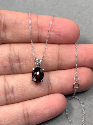 Oval garnet scroll pendant in 14K white gold