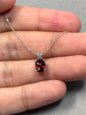 Oval garnet scroll pendant in 14K white gold
