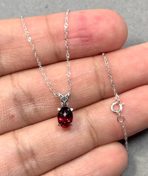 Oval garnet scroll pendant in 14K white gold