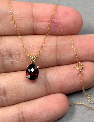 Oval garnet scroll pendant in 14K yellow gold