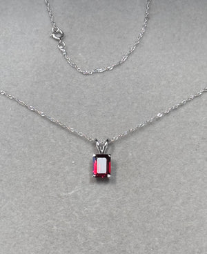 emerald cut garnet solitaire pendant in 14k white gold