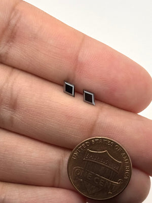 Matching pair of natural black lozenge-cut diamonds measuring 6x4mm with a total weight of 0.75 carats on a white background.
