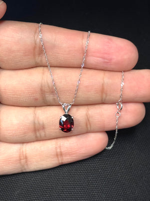 Oval AAA natural garnet solitaire pendant set in 14K white gold with four prongs, featuring a rich medium red 9x7 mm gemstone weighing 2.01–2.74 carats, finished with an elegant 18 inch white gold Singapore chain for women. 