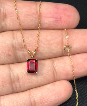 Emerald cut garnet solitaire pendant in 14K yellow gold