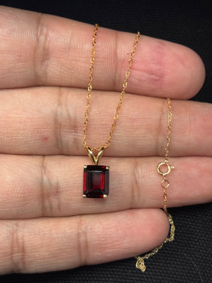 Emerald cut garnet solitaire pendant in 14K yellow gold