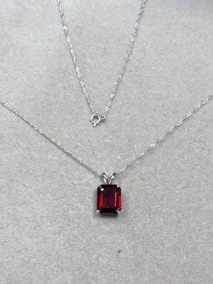 Emerald cut garnet solitaire pendant in 14K white gold