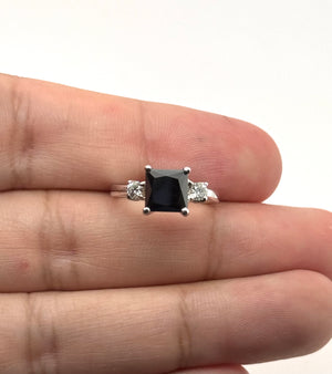 Side view of polished 18K white gold prongs showing the raised three-stone craftsmanship 