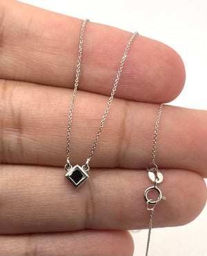 Side profile of a bezel-set 14K white gold pendant showing polished craftsmanship 