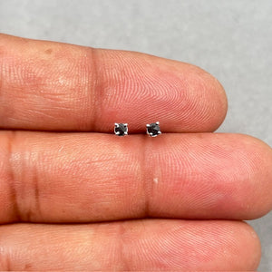 AA round rose cut black diamond stud earrings set in 14K white gold with four prong setting. Each stud measures 2.50–3.00 mm and features push back closures, showcasing a refined low-profile design with a soft vintage finish. 