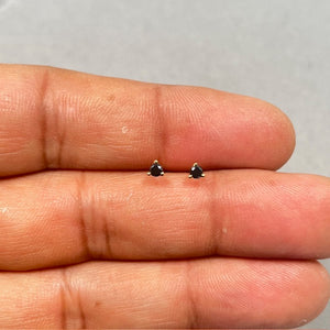 AAA round black diamond stud earrings set in solid 18K yellow gold with a secure three prong setting. These 2.50–3.00 mm solitaire studs feature push back closures and a refined minimalist look designed for women who prefer modern fine jewelry. 