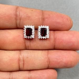 Emerald cut natural garnet cluster earrings in 14K white gold featuring 2.23 carat deep red garnets surrounded by 0.72 carat white diamonds in prong setting with secure push backs, elegant fine jewelry studs for women and January birthstone gift. 