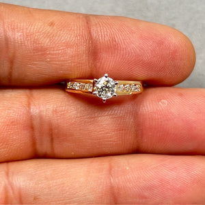 14K yellow gold women’s diamond fashion ring in size 6.5 featuring a prong set round center diamond accented by eight channel set side diamonds. Total diamond weight 0.60–0.65 carats with SI2–I1 clarity and I–J color. Slim 1.8–3.4 mm band, 2.52 grams gold weight, elegant fine jewelry design for everyday wear or special occasions. 