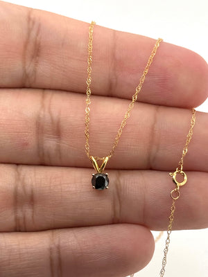 Side view of four-prong black diamond setting displaying polished solid 14K yellow gold craftsmanship 